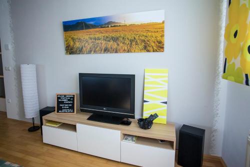 a flat screen tv sitting on top of a white cabinet at Goldenfields apartment in Kranj