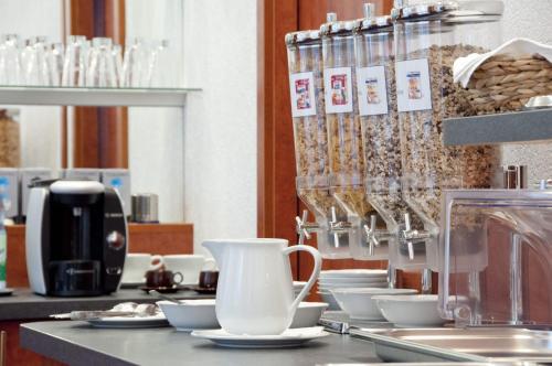 a counter with white cups and plates on it at Hotel West an der Bockenheimer Warte in Frankfurt/Main