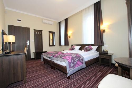 a hotel room with a bed and a television at Fisherman's House in Ustka