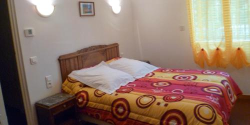 1 dormitorio con 1 cama con un edredón colorido en Les Hortensias en Millas
