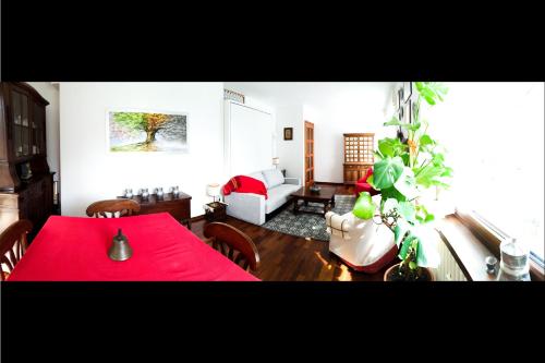 a living room with a red table and a couch at L'Atelier du Temps - PanoramAlps Apartment in Courmayeur