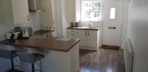 uma pequena cozinha com um balcão e um lavatório em Rookery Lodge Apartments em Wistaston