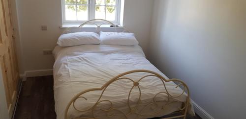 a small bed in a room with a window at Rookery Lodge Apartments in Wistaston