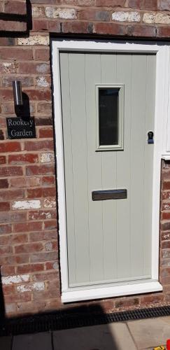 a white garage door on a brick wall at Rookery Lodge Apartments in Wistaston