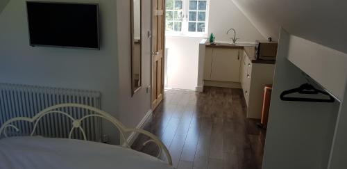 a room with a bed and a television on a wall at Rookery Lodge Apartments in Wistaston