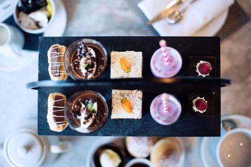 a tray of cupcakes and desserts on a table at Malmaison Liverpool in Liverpool