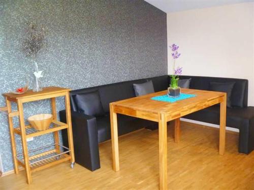 AnraffにあるFerienwohnung Bergblickの木製のテーブルと花が置かれたテーブルのあるソファ