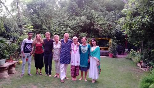 a group of people posing for a picture in a yard at The Coral Tree Boutique Homestay in Agra