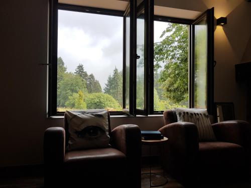a room with two chairs and a large window at Forester in Malmedy