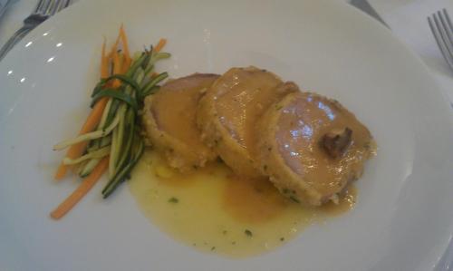 a white plate with a piece of meat with gravy and vegetables at Hotel Giannino in Porto Recanati