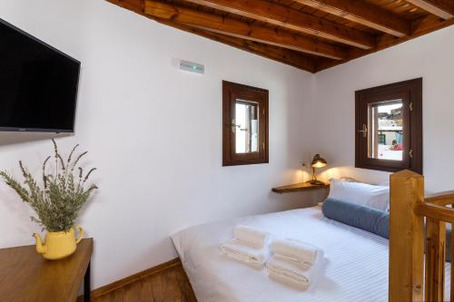 a bedroom with a bed and a flat screen tv at Lindos Vista Luxury Villa in Lindos
