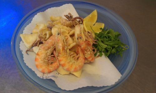 a blue plate of food with shrimp and vegetables at Hotel Giannino in Porto Recanati
