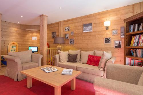 a living room with a couch and chairs and a table at Résidence Pierre & Vacances Premium Les Chalets du Forum in Courchevel