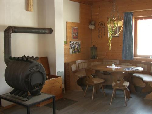 a living room with a wood stove and a table at Espi-Stables Ferienhof Esterhammer in Liebenau