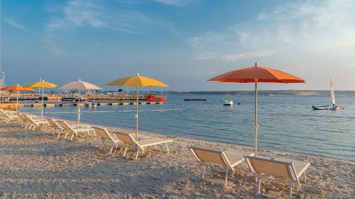 a group of chairs and umbrellas on a beach at Valamar Tamaris Resort in Tar