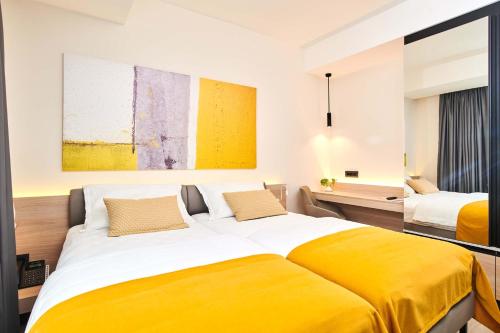 a bedroom with two beds and a yellow blanket at Apartments Park Plava Laguna in Poreč