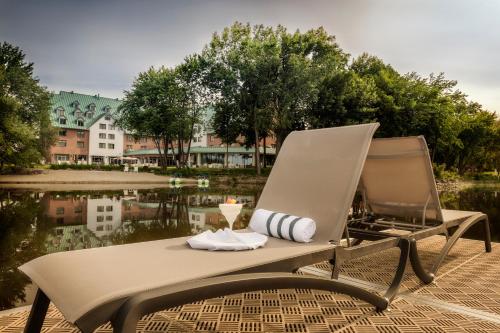 a chair with a drink on it next to a body of water at Chateau Vaudreuil in Vaudreuil-Dorion