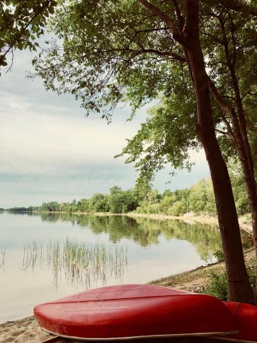 a red canoe sitting on the shore of a lake at Chateau Vaudreuil in Vaudreuil-Dorion