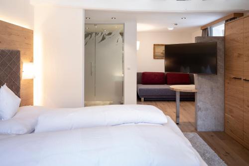 a hotel room with a bed and a flat screen tv at Isserwirt in Innsbruck