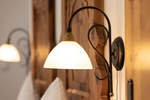 a lamp hanging on a wall next to a bed at Isserwirt in Innsbruck