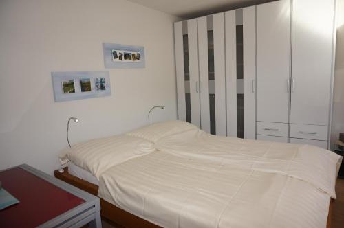アローザにあるParadies 606のベッドルーム(白いベッド1台、キャビネット付)