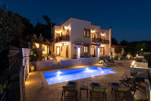 a villa with a swimming pool at night at Ageri Traditional Villa in Argyroupolis