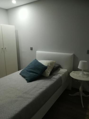 a bedroom with a bed with two pillows and a table at Casa Sr. Chico in Alvarenga