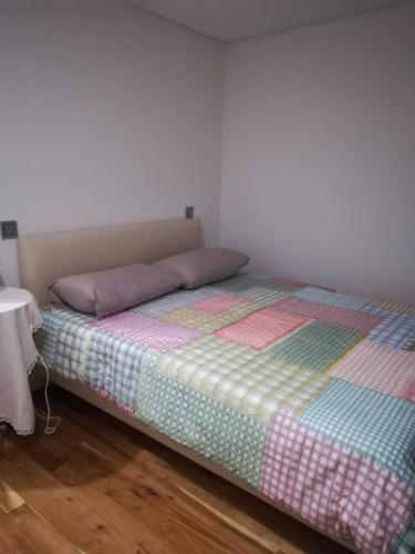 a bedroom with a bed with a colorful quilt on it at Casa Sr. Chico in Alvarenga
