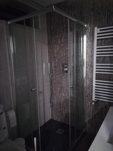a shower with glass doors in a bathroom at Casa Sr. Chico in Alvarenga