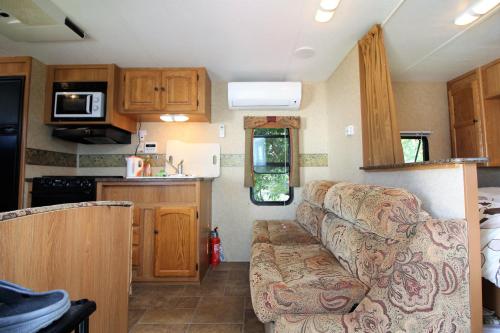 a small kitchen with a couch in a caravan at Tomareru Himitsukichi L-Base in Matsumoto