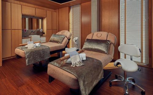 a living room with a chair and a barber shop at Hotel Jakarta Amsterdam in Amsterdam