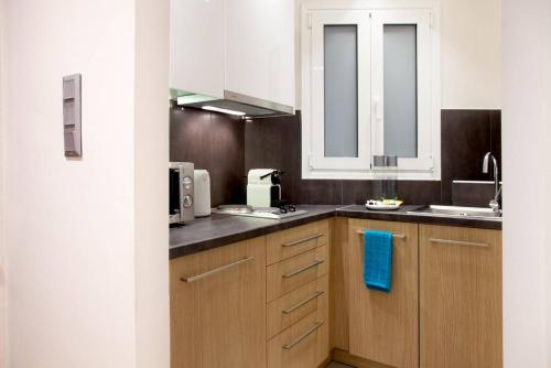 uma cozinha com armários brancos e uma toalha azul em TONI'S Brand-New Studio next to Syntagma Square em Atenas