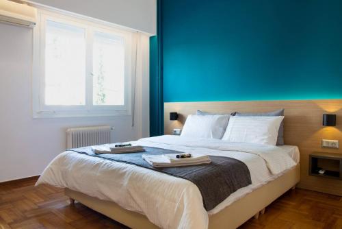 a bedroom with a large bed with a blue wall at TONI'S Brand-New Studio next to Syntagma Square in Athens