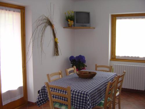 a dining room with a table and chairs and a tv at Casa Vacanze Michela in Santa Caterina Valfurva