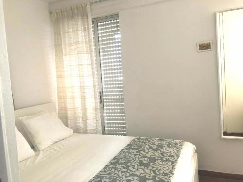 a small bedroom with a bed and a window at Sea-view maisonette at Sounio in Sounio