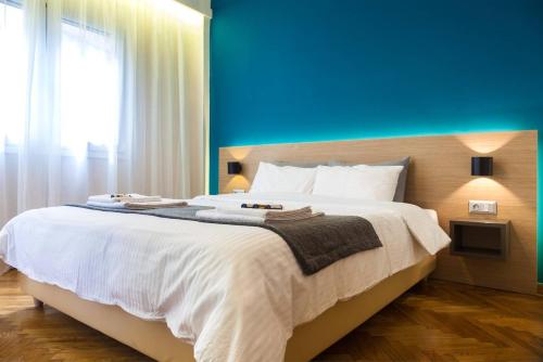 a bedroom with a large bed with a blue wall at TONI'S Classy Home in Kolonaki, local's Gem in Athens