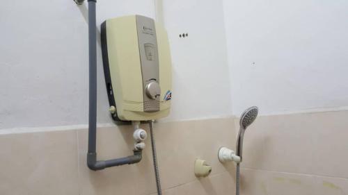 a soap dispenser on the wall of a bathroom at Homestay De MITC Melaka in Malacca