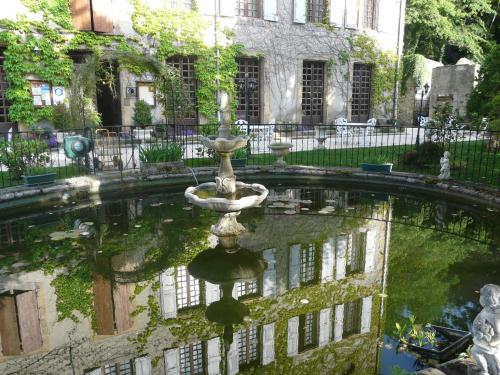 a fountain in the courtyard of a building at Logis Hostellerie Du Grand Duc hôtel restaurant in Gincla