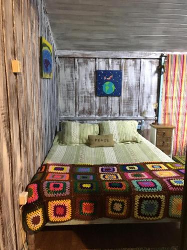 a bedroom with a bed in a wooden room at CasaHostel Floresce in Praia do Rosa