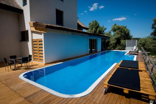 a swimming pool on a deck with a house at LivingIn Delta - Casa de Vacanta in Crisan