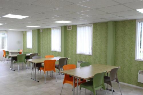 a classroom with tables and chairs and green walls at Sky Lodge Perth in Perth