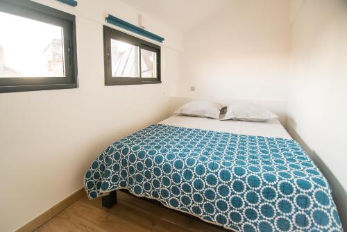 - une chambre avec un lit avec une couette bleue et 2 fenêtres dans l'établissement La Bohème Centre Historique - Terrasse sur les toits - HH, à Montpellier