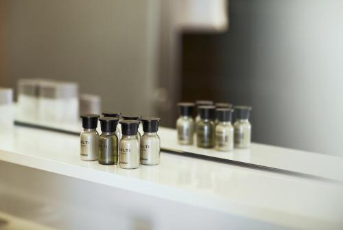 a row of perfume bottles sitting on a shelf at Hotel Uzwil in Uzwil