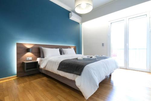 a bedroom with a large bed with a blue wall at TONI'S 2BD Modern flat in Koukaki near Acropoli in Athens