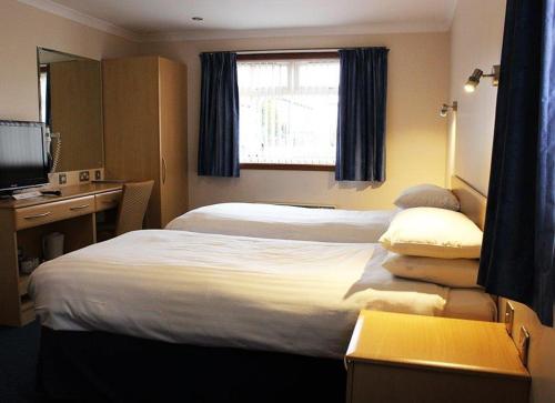 a hotel room with two beds and a television at Sky Lodge Perth in Perth