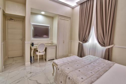 a bedroom with a bed and a desk and a television at The Moon Boutique Hotel & Spa in Florence