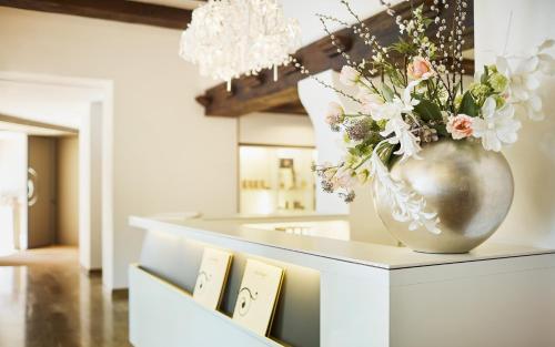 a vase with flowers on a counter in a room at Hotel Uzwil in Uzwil