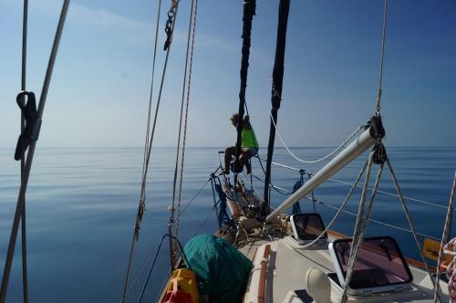 a man sitting on the bow of a boat in the water at Play to Live San Blas in El Porvenir