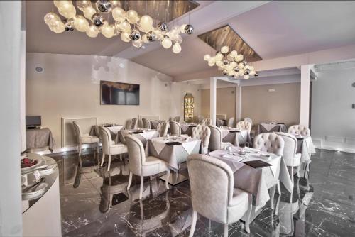 a dining room with tables and chairs and chandeliers at The Moon Boutique Hotel & Spa in Florence