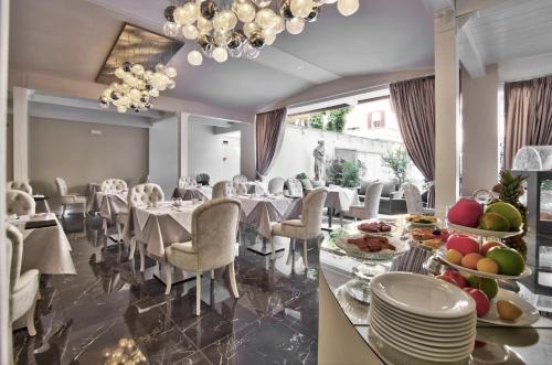 a dining room with tables and chairs and a chandelier at The Moon Boutique Hotel & Spa in Florence